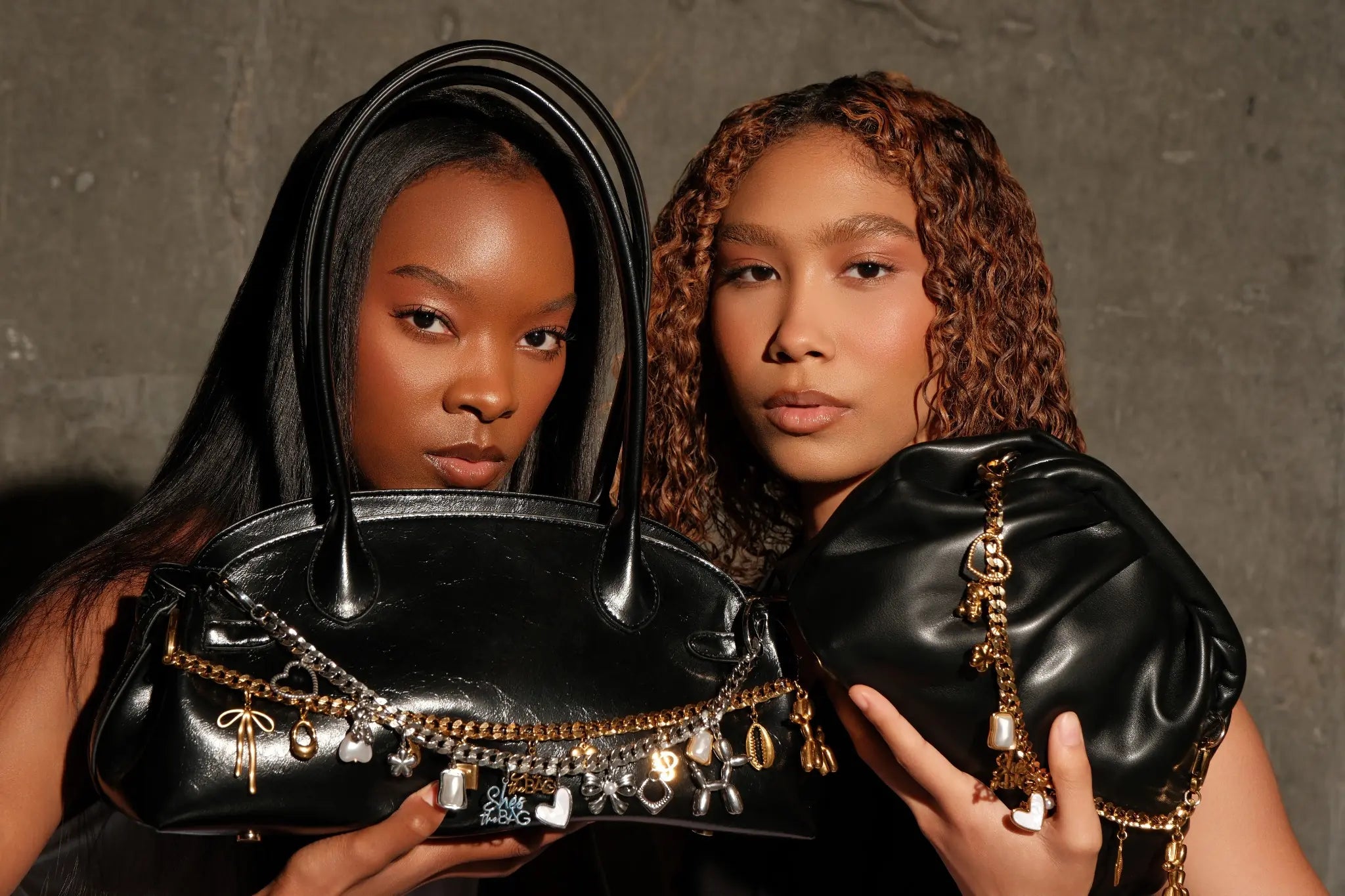 Models displaying gold and silver handbag charms